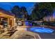 Evening view of hot tub and outdoor kitchen with stainless steel grill and outdoor seating area at 7607 Boca Raton Dr, Las Vegas, NV 89113