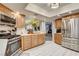 Well-equipped kitchen showcasing stainless steel appliances, wood cabinetry, tile floors, and ample counter space at 7607 Boca Raton Dr, Las Vegas, NV 89113