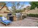 Beautiful outdoor kitchen with stainless steel grill, granite countertops, and brick patio area at 7607 Boca Raton Dr, Las Vegas, NV 89113