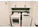 Functional laundry room with storage cabinets above washer and dryer at 7808 Wavering Pine Dr, Las Vegas, NV 89143