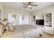 Bright bedroom features a ceiling fan, with an entertainment center and ensuite bathroom at 7828 Homing Pigeon St, North Las Vegas, NV 89084