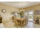 Bright dining area with sliding glass doors and a chandelier above the wooden dining table at 7828 Homing Pigeon St, North Las Vegas, NV 89084