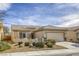 Inviting single-story home with a two-car garage and a well-maintained desert landscape at 7828 Homing Pigeon St, North Las Vegas, NV 89084