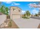 View of the two-story home and attached two car garage with extended driveway at 8324 Shark Tank Ct, Las Vegas, NV 89128