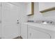 The laundry room has a side by side washer and dryer, with white cabinets above the appliances at 8324 Shark Tank Ct, Las Vegas, NV 89128