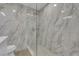 Modern shower with marble-look tiling, glass doors and dual shower heads at 8324 Shark Tank Ct, Las Vegas, NV 89128