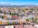 Overview of the neighborhood featuring uniform houses, manicured lawns, and a picturesque cityscape in the background at 840 Sheerwater Ave, Henderson, NV 89052