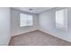 A bright bedroom features neutral carpet and two windows offering natural light at 840 Sheerwater Ave, Henderson, NV 89052