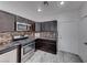 Well-equipped kitchen with stainless steel appliances, dark wood cabinets, and a decorative backsplash at 840 Sheerwater Ave, Henderson, NV 89052