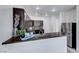 Kitchen with breakfast bar featuring dark cabinetry, granite countertops, and tile flooring at 840 Sheerwater Ave, Henderson, NV 89052