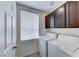 Bright laundry room featuring a white washer, dryer, and dark cabinets at 840 Sheerwater Ave, Henderson, NV 89052