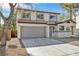 Two-story home with a gray garage door, desert landscaping, and neutral-colored exterior paint at 8979 Green Jade Dr, Las Vegas, NV 89129