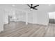 Spacious living room with wood-style flooring and adjacent kitchen with white cabinets at 8979 Green Jade Dr, Las Vegas, NV 89129