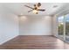 Bright bedroom features wood floors, ceiling fan, and sliding glass door to a balcony at 9124 Palatial Palette Ct, Las Vegas, NV 89149