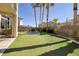 Serene backyard featuring artificial turf, palm trees, and a trampoline, ideal for relaxation and recreation at 9379 Arrowhead Bluff Ave, Las Vegas, NV 89149