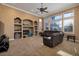 Spacious living room featuring a large window, built-in shelving, plush seating and a ceiling fan at 9379 Arrowhead Bluff Ave, Las Vegas, NV 89149