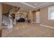 Spacious living room with a curved staircase, tile flooring, and a cozy carpeted area at 9379 Arrowhead Bluff Ave, Las Vegas, NV 89149