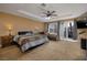 Comfortable main bedroom with ceiling fan, recessed ceiling, and sliding door access to the exterior at 9379 Arrowhead Bluff Ave, Las Vegas, NV 89149