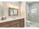 Bright bathroom featuring a vanity, large mirror, and tiled walk-in shower with glass door at 9809 Gerald Ct, Las Vegas, NV 89134