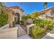 Charming front entrance with a decorative gate, lush greenery, and a welcoming double-door entry at 9809 Gerald Ct, Las Vegas, NV 89134