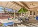 Inviting covered patio featuring a dining table and chairs, plus a green umbrella at 9809 Gerald Ct, Las Vegas, NV 89134