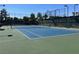 Outdoor tennis court with blue surface, surrounded by a fence and trees for recreational enjoyment at 9809 Gerald Ct, Las Vegas, NV 89134