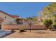 A backyard with mature trees and shrubbery set behind a brick wall at 9912 Woodhouse Dr, Las Vegas, NV 89134