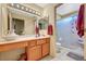 Well-lit bathroom features a wooden vanity, and a separate glass-enclosed shower area with a shower seat at 9912 Woodhouse Dr, Las Vegas, NV 89134