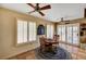 Cozy dining area featuring plantation shutters, modern ceiling fan, Saltillo flooring, and a decorative rug at 9912 Woodhouse Dr, Las Vegas, NV 89134