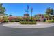 Beautiful building exterior featuring a roundabout entry, desert landscaping, and multiple flags on a clear day at 9912 Woodhouse Dr, Las Vegas, NV 89134