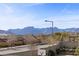 Neighborhood street view with desert landscaping, houses, and a mountain backdrop on a sunny day at 12135 Kite Hill Ln, Las Vegas, NV 89138