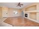 Open living room with wood-look floors, fireplace, ceiling fan, and sliding glass door to patio at 1292 Large Cap Dr # 3, Henderson, NV 89074