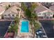Aerial view of a community pool with palm trees, lounge chairs, and nearby residential buildings at 1292 Large Cap Dr # 3, Henderson, NV 89074