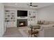 Living room with fireplace, built-in shelving, ceiling fan, and comfortable seating at 1921 Spyglass Dr, Henderson, NV 89074