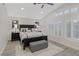 A stylish main bedroom with shuttered windows, ceiling fan, gray floors, and tasteful decor with a large black bed at 1921 Spyglass Dr, Henderson, NV 89074