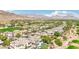 Stunning aerial view of luxury residences and golf course greens with desert mountains in the distance at 2690 Grassy Spring Pl, Las Vegas, NV 89135