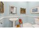 Stylish powder room with pedestal sink, decorative mirrors, and blue walls at 2690 Grassy Spring Pl, Las Vegas, NV 89135