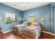 Charming bedroom with twin beds, hardwood floors, and blue accent wall at 2690 Grassy Spring Pl, Las Vegas, NV 89135