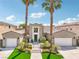 Beautiful two-story home featuring dual garages, a landscaped yard, and towering palm trees at 2690 Grassy Spring Pl, Las Vegas, NV 89135