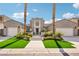 A modern home with a symmetrical facade, manicured lawn, and two-car garages under a blue sky at 2690 Grassy Spring Pl, Las Vegas, NV 89135