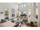 Spacious living room featuring a fireplace, a piano, and large windows with plenty of natural light at 2690 Grassy Spring Pl, Las Vegas, NV 89135