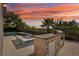 Outdoor kitchen with a built-in grill, sink, and mini-fridge, near the pool and spa area at sunset at 2690 Grassy Spring Pl, Las Vegas, NV 89135