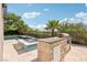Outdoor kitchen with a built-in grill, sink, and mini-fridge, near the pool and spa area at 2690 Grassy Spring Pl, Las Vegas, NV 89135
