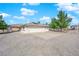 Exterior view of the property showcasing a three-car garage and additional covered parking, surrounded by desert landscaping at 2901 S Dandelion St, Pahrump, NV 89048