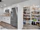 Modern kitchen with stainless steel appliances and well-stocked pantry with white shelving and wood-look floors at 2901 S Dandelion St, Pahrump, NV 89048