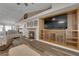 Open-concept living room with fireplace, TV, wood floors, and seamless flow to the dining area at 2901 S Dandelion St, Pahrump, NV 89048