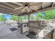 Covered outdoor kitchen equipped with a stainless steel grill, bar seating, and ceiling fans at 2901 S Dandelion St, Pahrump, NV 89048