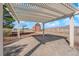 Inviting covered patio with paver flooring and a charming red barn-style shed in the distance at 2901 S Dandelion St, Pahrump, NV 89048