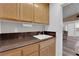 A wet bar with dark granite counters, wooden cabinets, and a sink at 2901 S Dandelion St, Pahrump, NV 89048