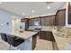 Well-lit kitchen featuring granite countertops, stainless steel appliances, and dark cabinets at 376 Shanon Springs St, Henderson, NV 89014